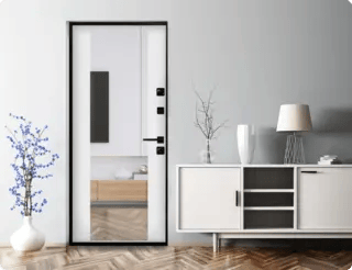 Входная дверь с зеркалом и чёрной фурнитурой подчёркивает стиль современного интерьера.