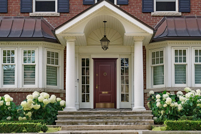 Парадная входная дверь в СПб. Дом облицован красным кирпичом с белыми декоративными элементами.