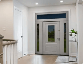 Входная дверь с окном и боковыми вставками подчёркивает стиль светлого интерьера.